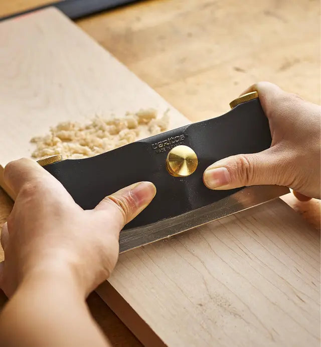 Woodworkier using the Veritas Cabinet Scraper Holder to scrape / smooth a piece of timber