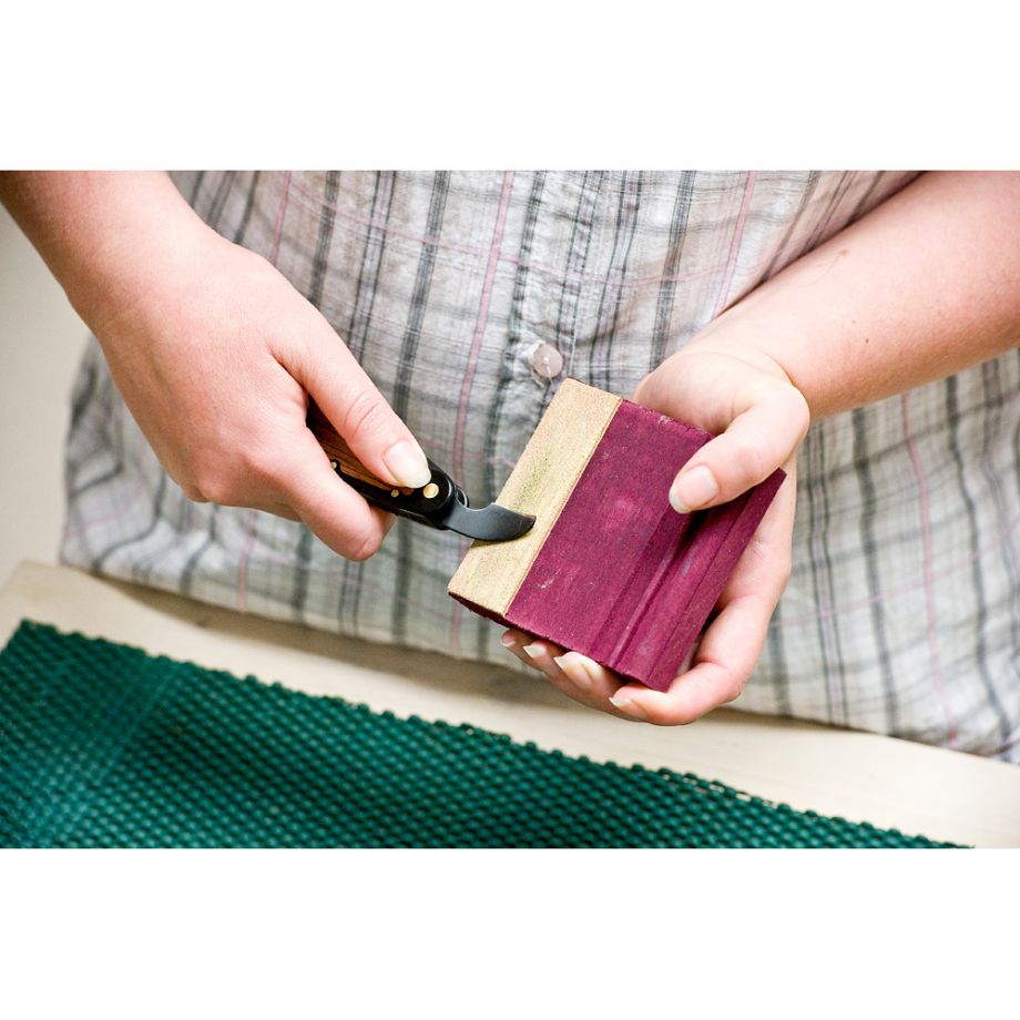 Woodcarver using the Flexcut SlipStrop to sharpen their carving tool