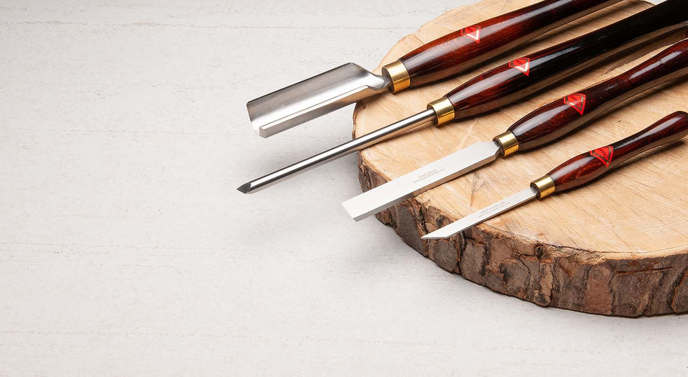 Henry taylor Woodturning Tools displayed on a rustic slab of timber.