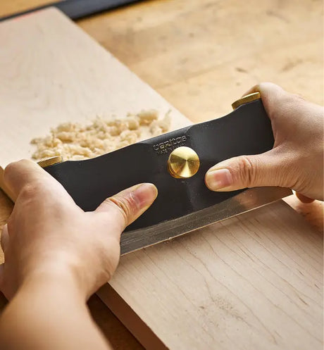 Woodworkier using the Veritas Cabinet Scraper Holder to scrape / smooth a piece of timber