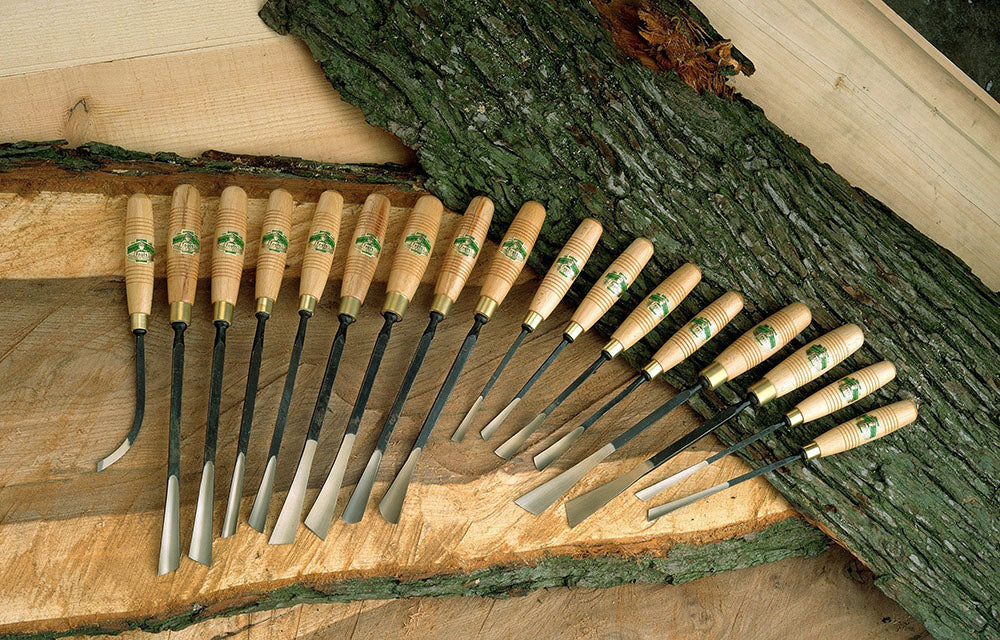 Henry Taylor Woodcarving Tools lined up on rustic slabs of timber.