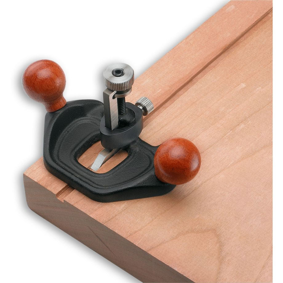 Veritas Miniature Router Plane being used to cut a groove into a sheet of wood