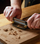 Woodworking using the Veritas Cabinet Scraper to finish a piece of timber.