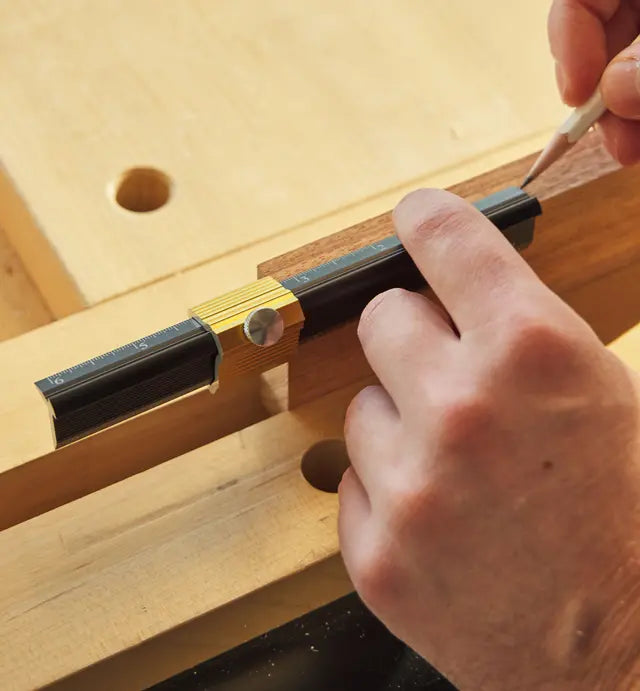 Veritas Edge Rule End Stop locked in place on rule while woodworker marks measurement onto wood