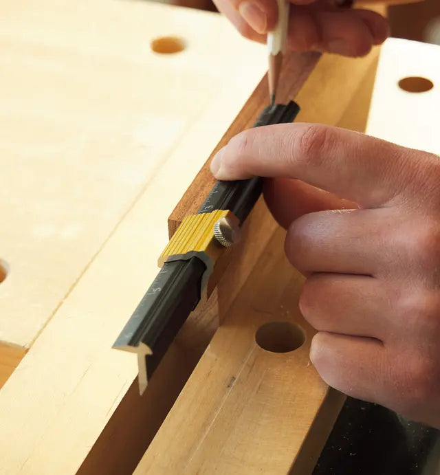 Veritas Edge Rule End Stop locked in place on rule while woodworker marks measurement onto wood