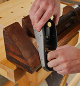 Veritas Mitre Plane being used to plane timber in a wooden mitre clamp